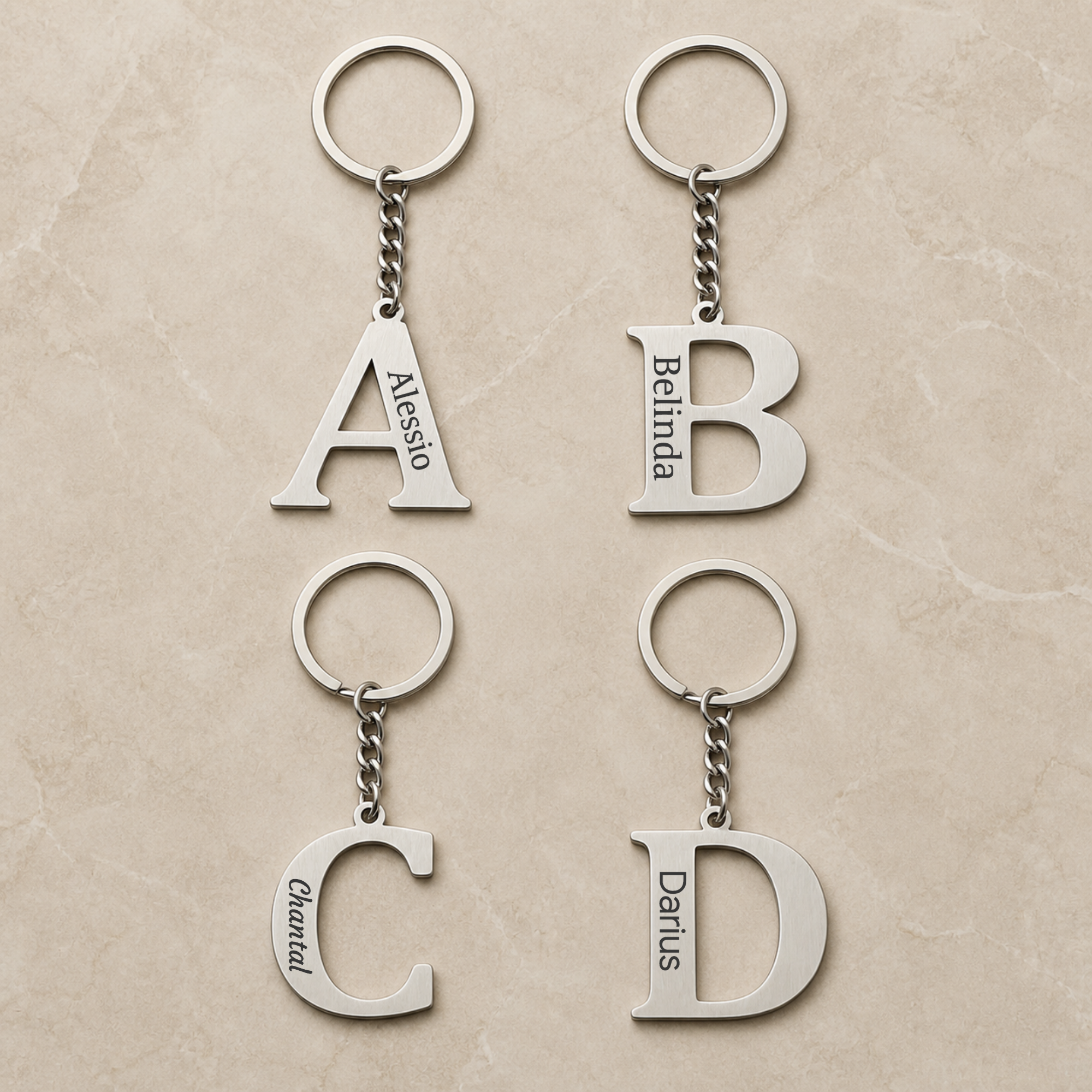 Vier silberfarbene Initial-Schlüsselanhänger A, B, C und D mit unterschiedlichen Namensgravuren. | all-groups