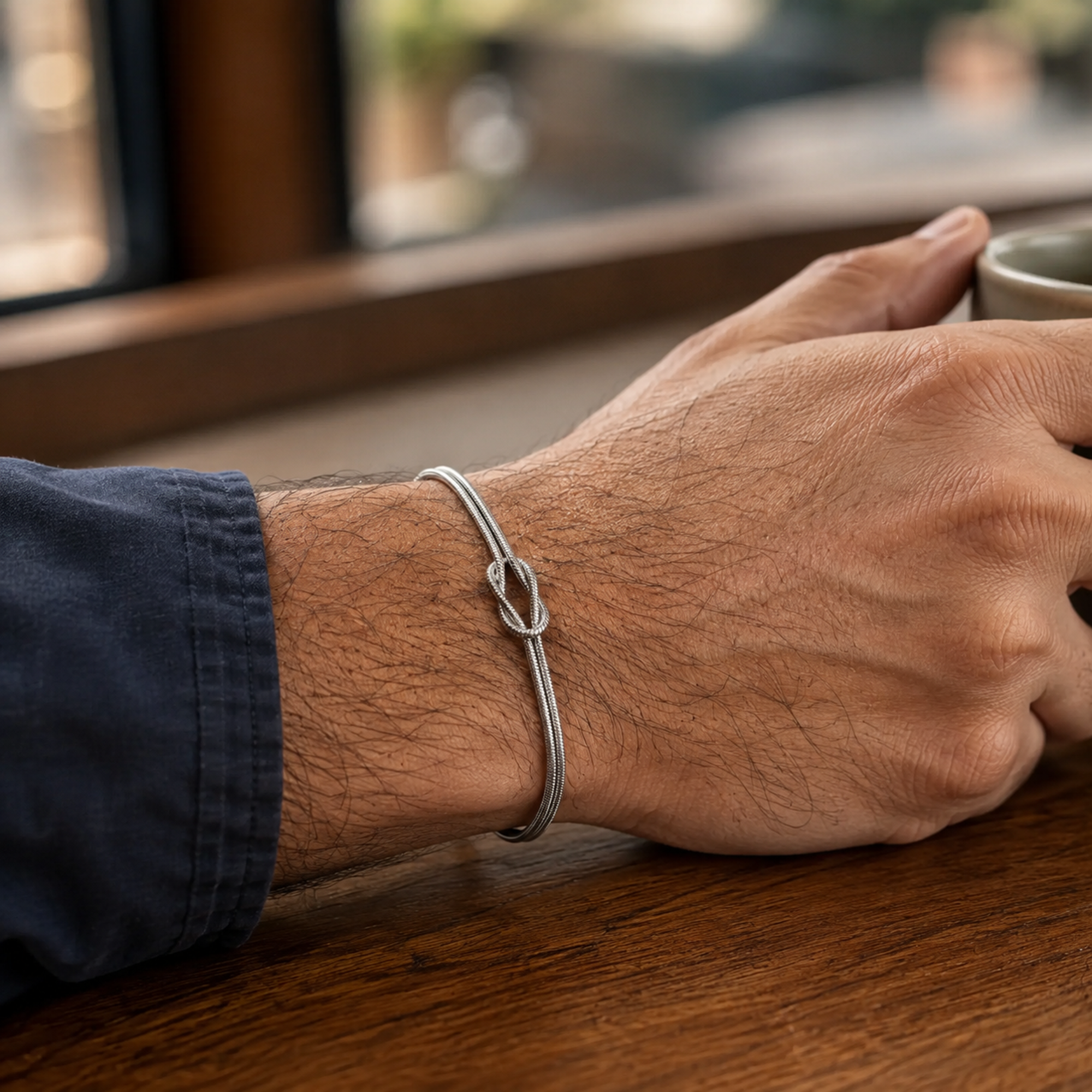 Silberfarbenes Knot Knotenarmband am Herrenhandgelenk all-groups