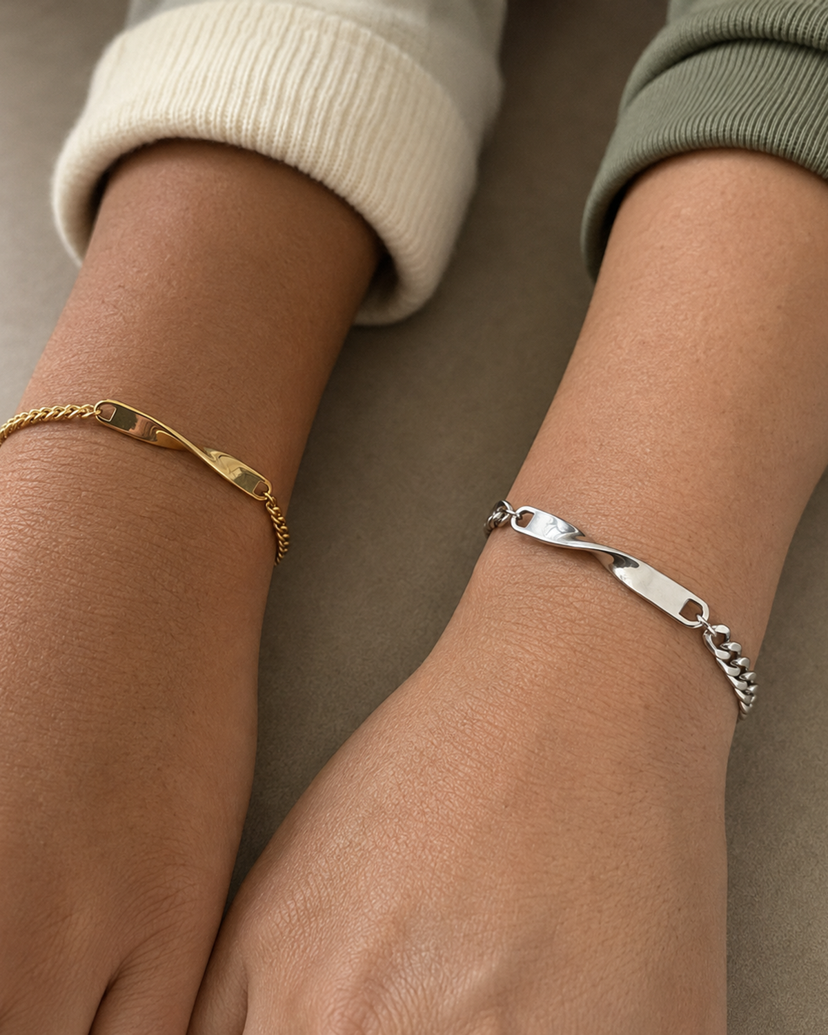 Kleines goldenes und großes silbernes Twist Armband an den Handgelenken zweier Freundinnen all-groups