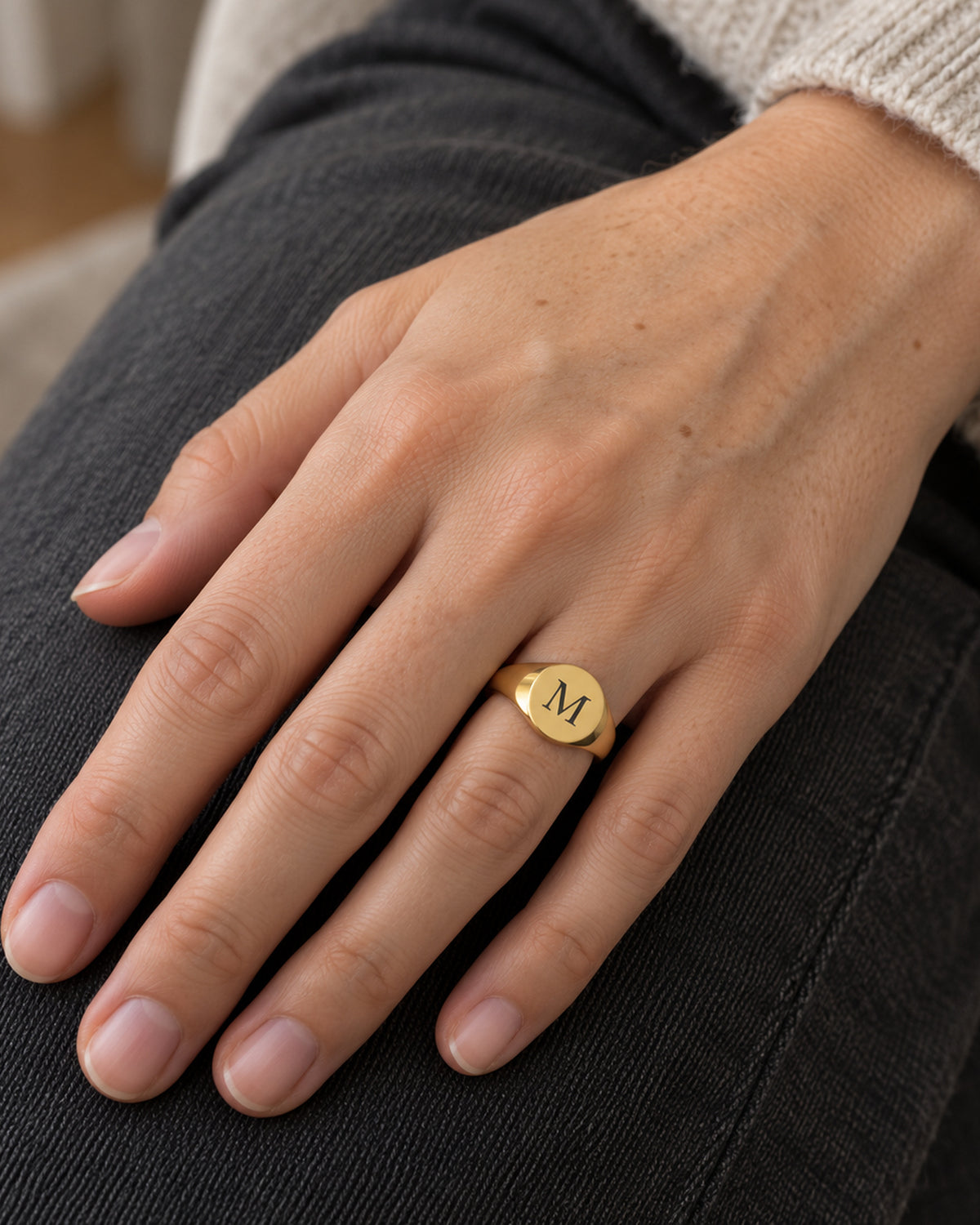 Coin Ring Gold mit Initiale M an einer Hand, KI-generierte Trageszene