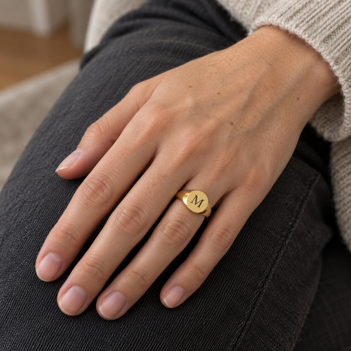 Coin Ring Gold mit Initiale M an einer Hand, KI-generierte Trageszene