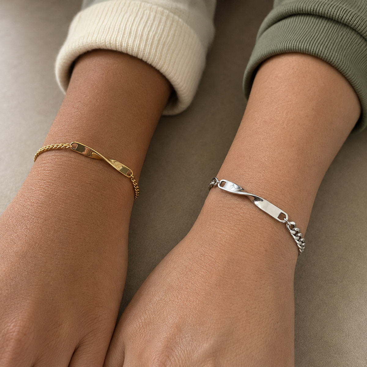 Kleines goldenes und großes silbernes Twist Armband an den Handgelenken zweier Freundinnen all-groups