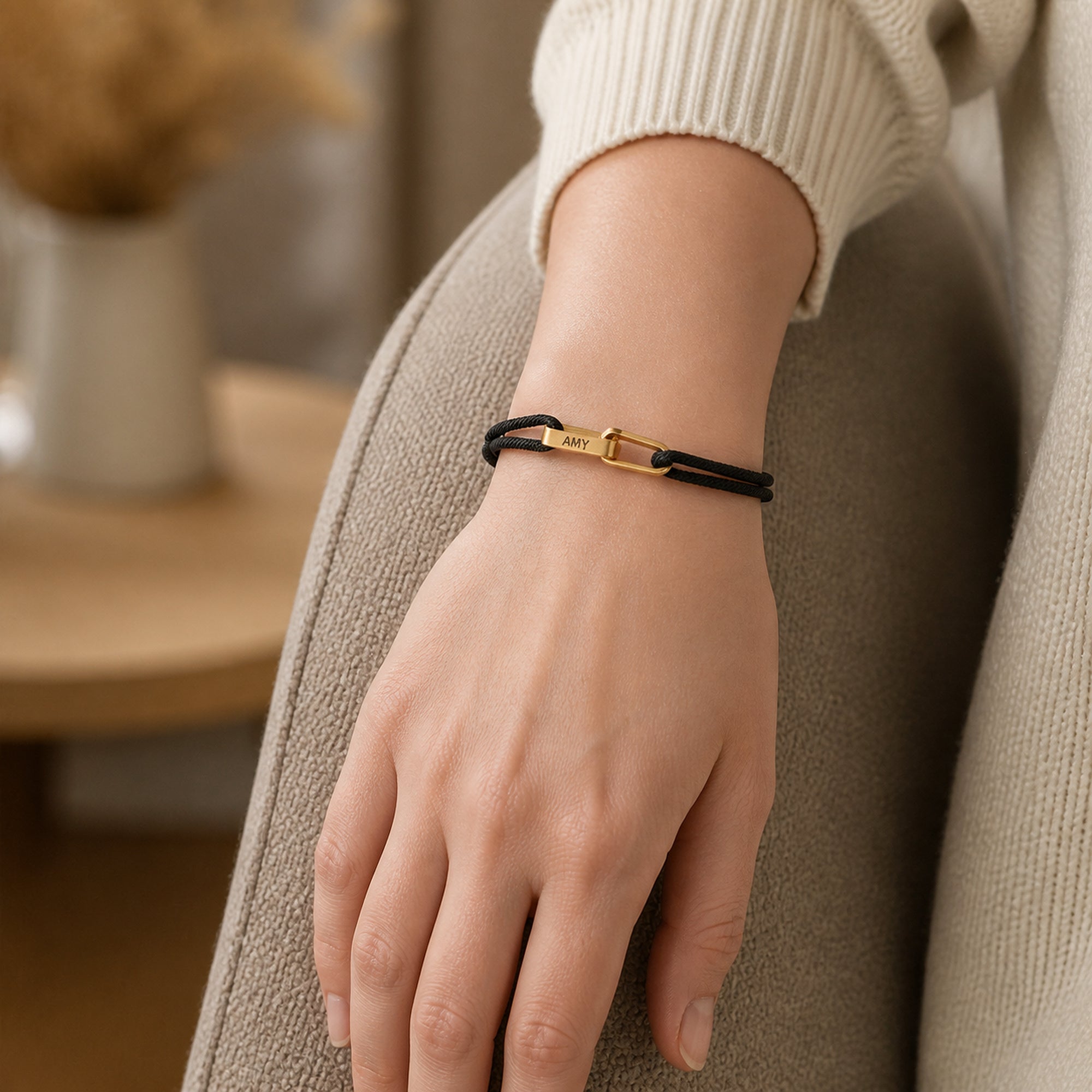 Frau trägt personalisiertes Kordelarmband mit Gravur am Handgelenk