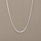 Sleek Chain in Silber auf warmem mineralischem Untergrund