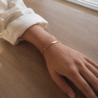 Schmales Twist Armband in Gold am Handgelenk all-groups